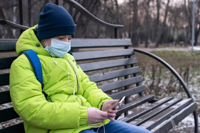 teen-boy-bench-headphones-phone-hat-jacket-green-medical-mask-use-person-child-outdoor-communication_t20_gLr8oN
